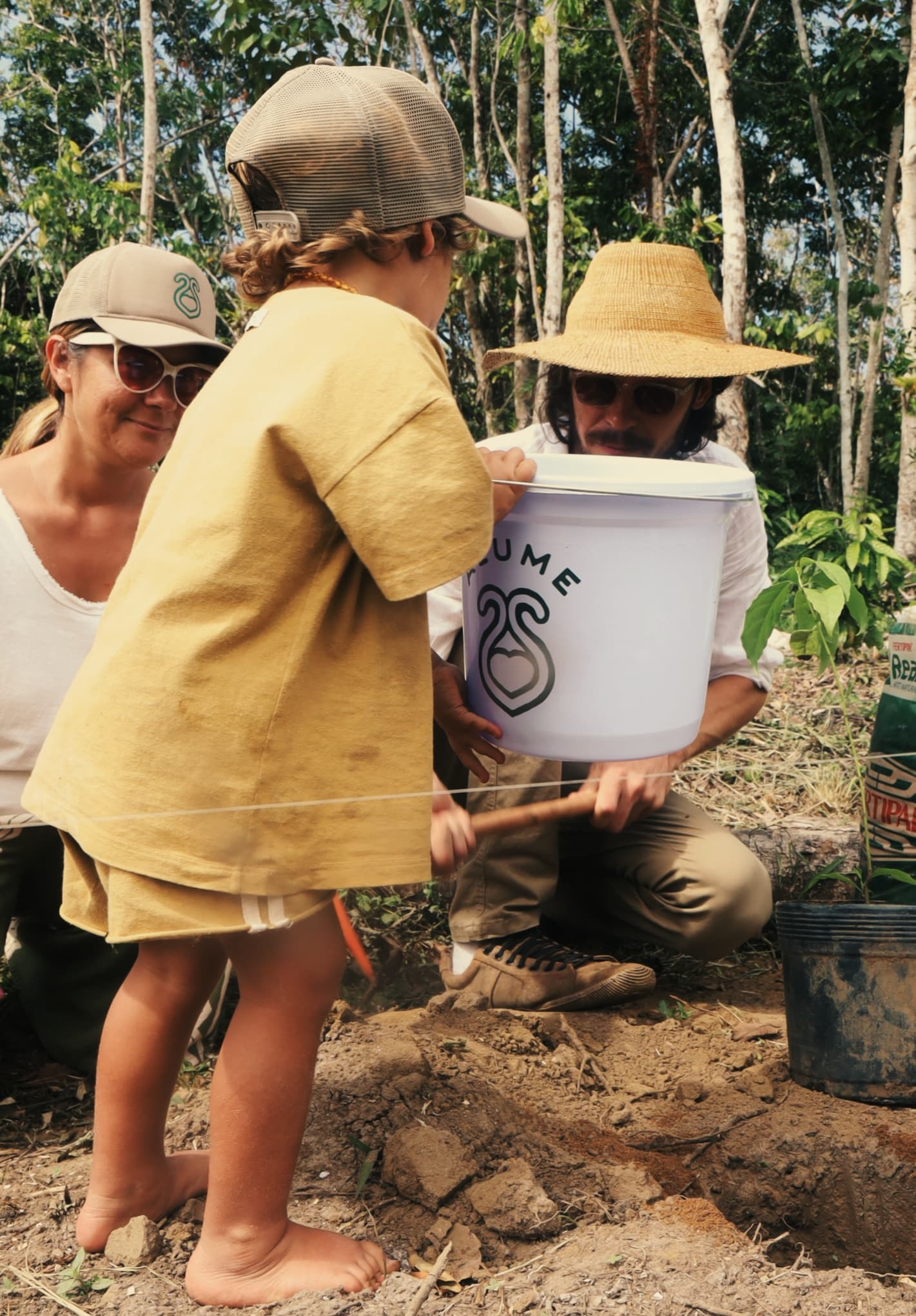 Family participating in regenerative planting at Fazenda ALUME